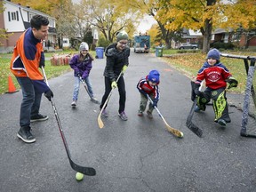 Just for fun: Jason Duke plays road hockey with his children, from left, Clara, Ella, Lennon and Nolan outside their home in Pointe-Claire.