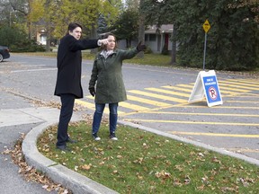 Parents Kristopher Parent, left, and Dominique Godin discuss where they think a sidewalk should go at the drop-off/pick-up area in front of École primaire Saint-Remi in Beaconsfield on Tuesday, November 1, 2016.  They argue that the area is cramped and a sidewalk would safely separate the vehicles from the pedestrians.  (Phil Carpenter / MONTREAL GAZETTE)