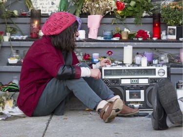 Natasha Nuhanovic, a fan of Leonard Cohen sits at a makeshift memorial outside the late singer/songwriter's house on Vallières in Montreal, Friday November 11, 2016.  Cohen died in 82 overnight on Thursday the 10th.