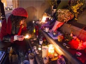 Natasha Nuhanovic contributes to a makeshift memorial at Leonard Cohen's  house on Vallières St. in Montreal on Nov. 11.