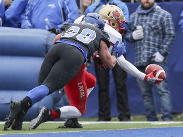 Laval Rouge et Or receiver Jonathan Breton-Robert reaches the football across the goal line for a touchdown while being defended by Carabins de Université de Montréal's Vincent Jacques during the Quebec university football championship game in Montreal on Saturday, Nov. 12, 2016.