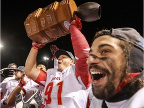 Laval Rouge et Or's Clement Lebreux raises the Dunsmore Cup while celebrating with teammate Anthony Dufour, right, following victory over the Carabins de Université de Montréal in the Quebec university football championship game in Montreal on Saturday, Nov, 12, 2016.