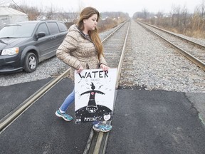 Melissa Montour crosses train tracks in Kahnawake Mohawk community, south of Montreal, Nov. 16, 2016, as anti-pipeline protesters camp nearby.