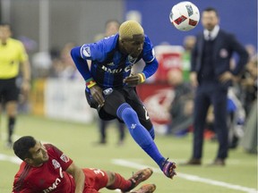 Montreal Impact's Ambroise Oyongo goes over Toronto FC's Steven Beitashour during first half action in game 1 of the MLS Eastern Conference final held at Olympic stadium in Montreal on Tuesday November 22, 2016.