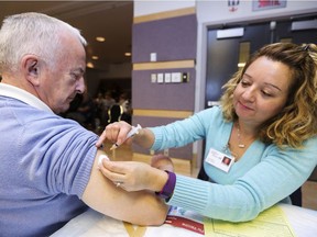 Andrew Phillips gets a flu shot from nurse Dalia Toledano at the Dollard Civic Centre in Dollard des Ormeaux on Thursday November 24, 2016. (John Mahoney / MONTREAL GAZETTE) ORG XMIT: 57632 - 6376