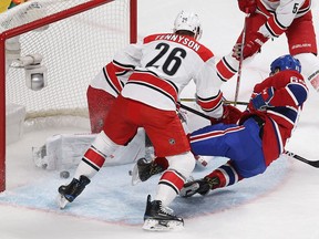Montreal Canadiens' Andrew Shaw (65) scores on Carolina Hurricanes goalie Cam Ward as Matt Tennyson (26) brings Shaw down to the ice, during first period NHL action in Montreal on Thursday November 24, 2016.