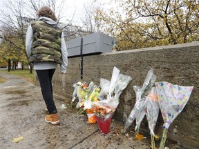 A young man walks by a makeshift memorial for a teenage boy who was stabbed to death recently on L'Île-des-Soeurs Blvd. on Nuns' Island in Montreal Thursday November 3, 2016. (John Mahoney / MONTREAL GAZETTE)