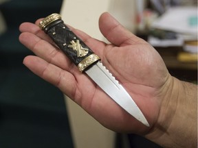 Professional piper Jeff McCarthy shows off a sgian-dubh (dark or hidden knife) at home in Montreal, Thursday November 3, 2016.