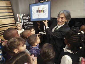 MSO conductor Kent Nagano holds up a drawing presented to him by a student at École St-Remi in Montreal North.