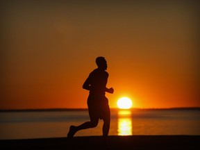 A runner is silhouetted by the setting sun in Lachine.