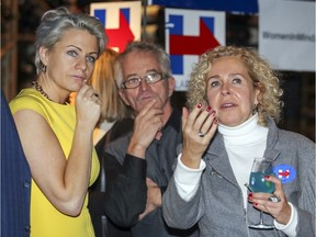 Helene Roger, left, Gilles Desranleau and Korine Hazan watch early results from the U.S. presidential election at an event organized by Women in Mind, a neighbourhood social network created by and for women, at a restaurant in the the Nuns' Island district of Montreal Tuesday Nov. 8, 2016.