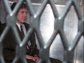 Notorious killer Paul Bernardo arrives at the provincial courthouse in the back of a police van wearing handcuffs and leg irons, in Toronto in a November 3, 1995, file photo.