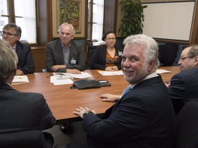Quebec Premier Philippe Couillard, foreground, meets Assembly of First Nations of Quebec and Labrador Ghislain Picard, back, and a delegation of natives, Wednesday, Nov. 30, 2016 at his office in Quebec City.