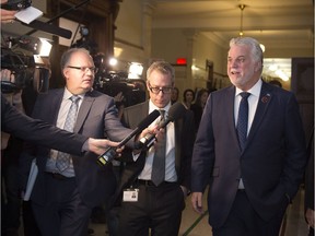 Quebec Premier Philippe Couillard walks past reporters after a caucus meeting at the provincial legislature, in Quebec City on Wednesday, November 2, 2016. To its credit, the Couillard government, which first had announced more limited measures, was quick to see the need for a broader inquiry into revelations about police spying on journalists.
