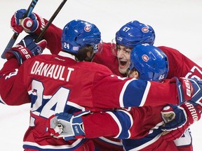 Canadiens' Phillip Danault (24) celebrates with teammates Max Pacioretty (67) and Andrew Shaw (65) after scoring against the Detroit Red Wings during first period NHL hockey action in Montreal, Saturday, November 12, 2016.