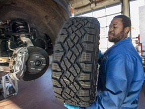 Jason Lespoir installs winter tires on a costomer's pickup truck at Gordon's Tires in Montreal, on Saturday, November 19, 2016.