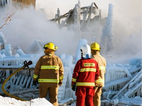 Firefighters look at the smouldering remains of a seniors residence in L'Isle-Verte.