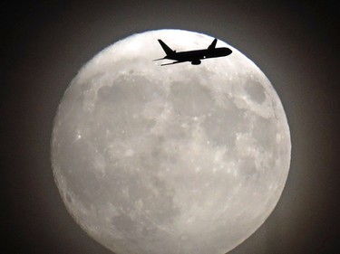 A commerical jet flies in front of the moon on its approach to Heathrow airport Nov. 13, 2016. Tomorrow, the moon will orbit closer to the earth than at any time since 1948, named a 'supermoon', it is defined by a Full or New moon coinciding with the moon's closest approach to the Earth.