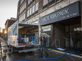 A cleanup crew removes debris from a building that suffered extensive damage from an overnight fire near the corner of Victoria Ave. and Sherbrooke St. in Westmount on Nov. 14, 2016. The building houses the restaurants Park and Lavanderia from Chef Antonio Park.