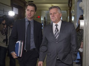Quebec Transport Minister Laurent Lessard, right, leaves a party caucus meeting with press attaché Mathieu Gaudreault on Tuesday, Dec. 6, 2016. at the legislature in Quebec City.