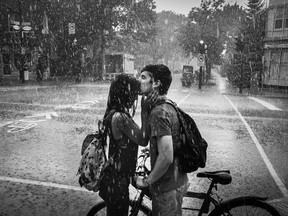 Michael Ponente and his girlfriend Knikita Naitram kiss as they're caught in a sudden summer rainstorm on Jarry street in the Villeray neighbourhood in Montreal on Monday, July 18, 2016.