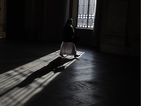 A nun walks through a building.