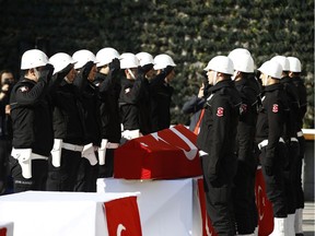 Colleagues salute as they attend a memorial for police officers killed outside the Besiktas football club stadium Vodafone Arena late Saturday, in Istanbul, Sunday, Dec. 11, 2016. Turkey declared a national day of mourning Sunday after twin blasts in Istanbul killed dozens of people and wounded many others near a soccer stadium — the latest large-scale assault to traumatize a nation confronting an array of security threats.