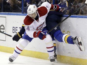 Canadiens' Tomas Plekanec and St. Louis Blues' Colton Parayko, rear, get tangle up while chasing after a loose puck along the boards during the first period of an NHL hockey game Tuesday, Dec. 6, 2016, in St. Louis.