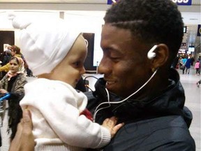 Darius Brown holds a young relative while welcoming him at Trudeau airport. A youth pleaded guilty in the slaying of Brown, a popular N.D.G. teen.