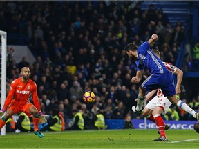 Chelsea's Brazilian-born Spanish striker Diego Costa (2nd R) shoots past Stoke City's English goalkeeper Lee Grant (L) to score their fourth goal during the English Premier League football match between Chelsea and Stoke City at Stamford Bridge in London on Saturday, Dec. 31, 2016.