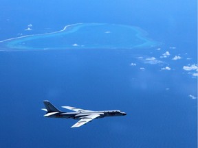 In this undated file photo released by Xinhua News Agency, a Chinese H-6K bomber patrols the islands and reefs in the South China Sea.