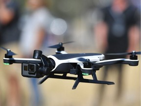 (FILES) This file photo taken on September 19, 2016 shows a GoPro Karma foldable drone  seen flying during a press event in Olympic Valley, California.  Ford Motor Co. is studying a system to use drones to help guide self-driving vehicles, including on off-road adventures, company officials said. Drones launched from an autonomous vehicle would help guide it by mapping the surrounding area beyond what the car's sensors can detect. Vehicle passengers can control the drone using the cars infotainment or navigation system.    /