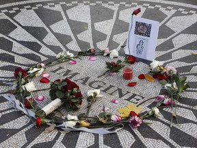 Flowers and a homemade tribute left by fans of the legendary musician adorn a memorial to John Lennon at Strawberry Fields in Central Park, one day before the 35th anniversary of his death, Dec. 7, 2015, in New York.