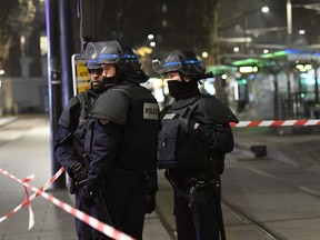 French police officers stand guard as a security perimeter was established after a robber armed with a handgun held seven people in a travel agency on the Massena boulevard, in the Porte d'Italie area in the south of Paris, on December 2, 2016.
