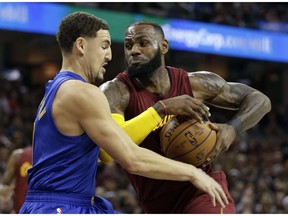 Cleveland Cavaliers' LeBron James, right, drives to the basket against Golden State Warriors' Klay Thompson in the first half of an NBA basketball game, Sunday, Dec. 25, 2016, in Cleveland. The Cavaliers won 109-108.