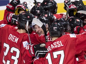 Switzerland's Loic In Albon, centre, is surrounded by teammates as they celebrate their 5-4 victory over Denmark in the shootout at IIHF World Junior Championship hockey Friday, Dec. 30, 2016, in Montreal.