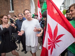 Marc Emery and his wife Jodie are surrounded by media and well wishers as they walk near the border crossing in Windsor, Ontario, Tuesday, August 12, 2014. Canada's self-styled "Prince of Pot" returned home after serving his U.S. sentence for selling marijuana seeds to customers across the border.