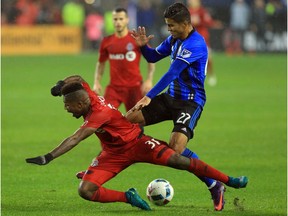 Armando Cooper of Toronto FC and Johan Venegas of Montreal Impact battle for the ball during the second half of the MLS Eastern Conference Final, Leg 2 game at BMO Field on November 30, 2016 in Toronto.