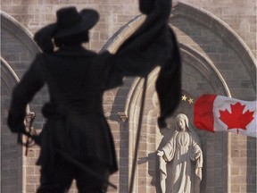 Statue of Paul de Chomedey silhouetted against Notre Dame Basilica.