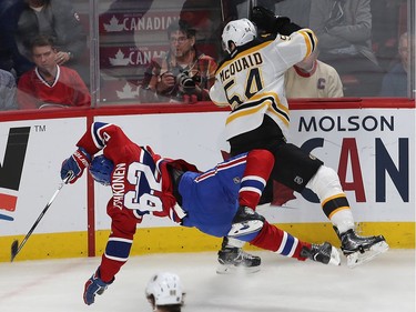 Montreal Canadiens' Artturi Lehkonen (62) and Boston Bruins' Adam McQuaid (54) flip in the air after colliding during third period NHL action in Montreal on Monday December 12, 2016.