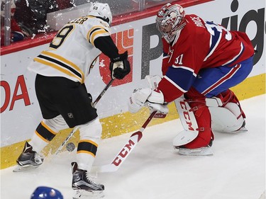 Montreal Canadiens goalie Carey Price and Boston Bruins' Tim Schaller (59) mix it up for control of the puck behind the net during second period NHL action in Montreal on Monday December 12, 2016.
