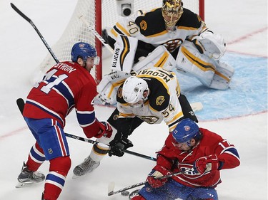 Montreal Canadiens' Torrey Mitchell (17) falls to ice next to the puck while Boston Bruins' Adam McQuaid (54) and Montreal Canadiens' Paul Byron (41) try to get to it, during first period NHL action in Montreal on Monday December 12, 2016.
