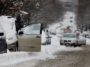 People dig their cars out of the snow along Richmond St. in the Little Burgundy district of Montreal on Monday December 12, 2016.