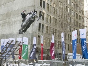 A stunt performer powers a snowmobile mid-air off a ramp, during a freestyle snowmobile demonstration in downtown Montreal, Wednesday December 14, 2016. The demonstration was a promotion for snowmobiling championships to be held February 4-5, 2017 downtown as part of the city's 375th anniversary celebrations.
