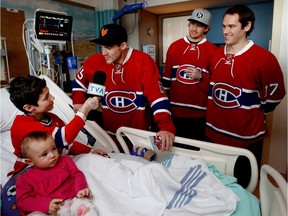 Elowan Gingras interviews Montreal Canadiens centre Andrew Shaw during the Montreal Canadiens annual visit to the Shriner's Hospital for Children in Montreal on Wednesday December 14, 2016. Gingras told the Canadiens his dream is to become a hockey analyst, TVA turned the microphone over to Gingras to conduct his first hockey interview. Gingras, 12, asked Shaw how he felt the first moment he heard that he had been traded to the Canadiens. Montreal Canadiens defenceman Jeff Petry and centre Torrey Mitchell, right, listen in. One year old Emmalia Houle sits with her brother during the interview.