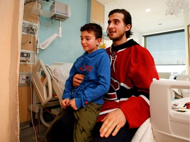 Montreal Canadiens left wing Phillip Danault holds Zachary Dubrovsky as he speaks with Zachary's brother Joshua during the Montreal Canadiens annual visit to the Montreal Children's Hospital in Montreal on Wednesday Dec. 14, 2016.