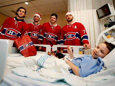 Ten-year-old Hayden Stenlund is all smiles as his mother Theresa tells Montreal Canadiens left wing Phillip Danault, left to right, goalie Al Montoya, centre Alex Galchenyuk and defenceman Andrei Markov, that Hayden's sister plays on three different hockey teams. Hayden, from Kenora, Ont., has been in the Children's Hospital since Dec. 5th and hopes to be home for Christmas.