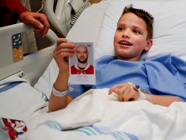 Ten-year-old Hayden Stenlund smiles after being giving a Montreal Canadiens defenceman Andrei Markov card during the Montreal Canadiens annual visit to the Montreal Children's Hospital on Wednesday Dec. 14, 2016.