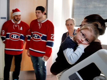 Three-year-old Laurie Ann Michaud rests on her mother, Chantal Archambault, as she speaks with Montreal Canadiens left wing Phillip Danault, left to right, defenceman Andrei Markov and centre Alex Galchenyuk during the Montreal Canadiens annual visit to the Montreal Children's Hospital on Wednesday Dec. 14, 2016.
