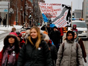 A group of people march along Berri St. in Montreal on Dec. 18, 2016. The group walked 16 kilometres to protest against the Enbridge Line 9B pipeline and Bill 106, which gives companies the right to expropriate land to extract oil.
